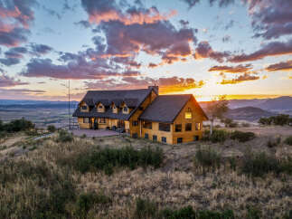 Experience breathtaking sunset views from this stunning log home, perched atop a hill with panoramic vistas of the valley and mountains.