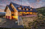 Experience luxury mountain living in this stunning log home, perfectly situated to capture breathtaking sunset views.