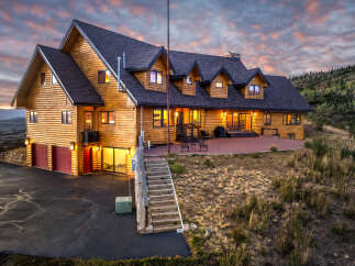Experience luxury mountain living in this stunning log home, perfectly situated to capture breathtaking sunset views.