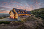 Experience breathtaking mountain living in this stunning log home, perfectly situated on a hilltop with panoramic views.