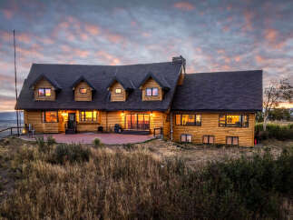Experience luxury mountain living in this stunning log home, perfectly situated to capture breathtaking sunset views.