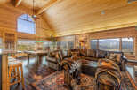 Experience rustic luxury in this stunning mountain lodge featuring a spacious living area with a large leather sectional and a pool table.