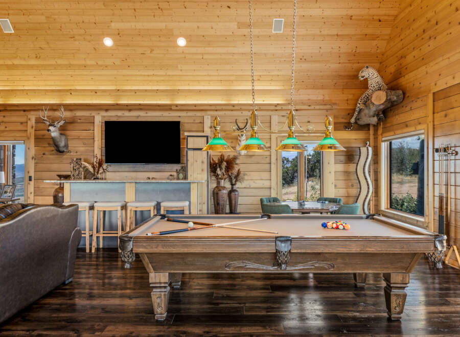 Experience rustic luxury in this spacious game room, featuring a professional billiard table perfect for evening entertainment.
