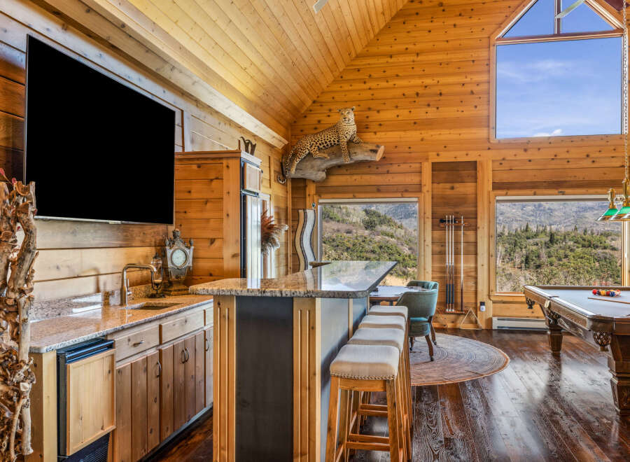 Experience ultimate relaxation in this stunning log cabin retreat, featuring a fully equipped bar area with granite countertops and a mini-fridge, perfect for entertaining.