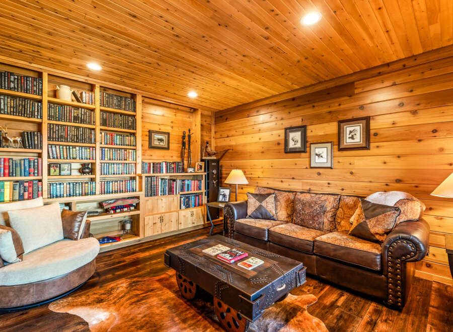 Step into a cozy den featuring rich wood paneling throughout, creating a warm and inviting atmosphere.