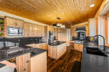 Experience luxury in this stunning kitchen featuring custom light wood cabinetry and sleek black granite countertops.