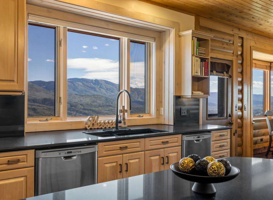 Experience breathtaking mountain views from this stunning kitchen, featuring a large sink area with a 'Blessed' accent and a modern faucet.