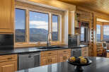 Experience breathtaking mountain views from this stunning kitchen, featuring a large sink area with a 'Blessed' accent and a modern faucet.