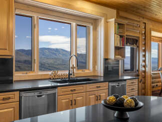 Experience breathtaking mountain views from this stunning kitchen, featuring a large sink area with a 'Blessed' accent and a modern faucet.