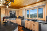 Experience breathtaking mountain views from this stunning kitchen, featuring a spacious island with granite countertops and a full suite of stainless steel appliances.