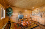 This rustic office space features warm wood paneling on the walls and ceiling, creating a cozy and inviting atmosphere.