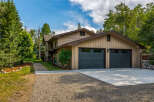 This charming home features a spacious two-car garage with modern dark gray doors, perfect for vehicle storage and hobbies.