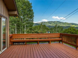 Enjoy breathtaking mountain views from this expansive wooden deck, perfect for outdoor entertaining or quiet relaxation.