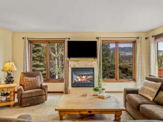 Cozy living room featuring a stone-tiled fireplace with a roaring fire, perfect for chilly evenings.