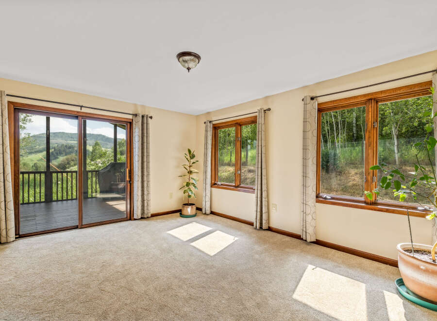 Experience breathtaking mountain views from this spacious room, featuring a large sliding glass door that opens to a private deck.