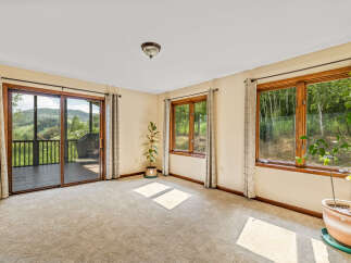 Experience breathtaking mountain views from this spacious room, featuring a large sliding glass door that opens to a private deck.