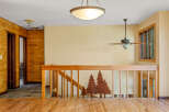 This charming interior features warm wood paneling and a beautiful wooden staircase with a unique tree silhouette design.