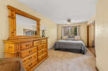 This cozy bedroom features a spacious wooden dresser with a large mirror, perfect for storing your belongings and getting ready.