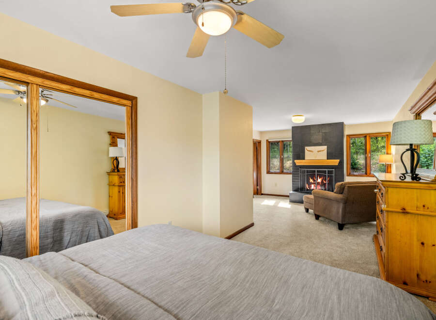 Experience ultimate comfort in this spacious bedroom featuring two cozy beds and a relaxing seating area with a fireplace.