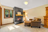 Cozy up by the inviting fireplace in this charming living room, featuring a striking black tile surround and a warm wooden mantel.