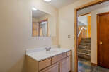 This bathroom features a light wood vanity with a white countertop and a modern chrome faucet.