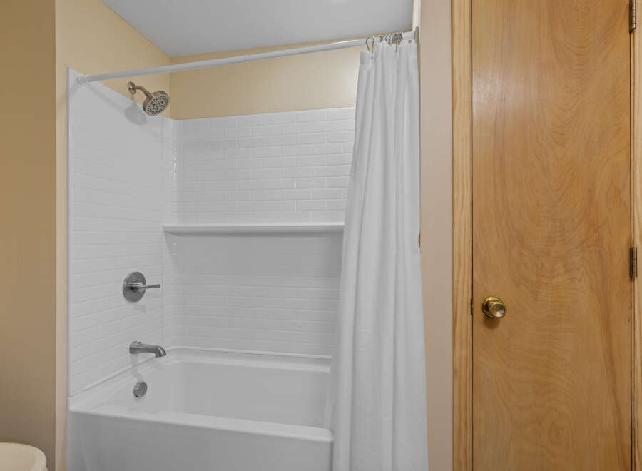 Step into this clean and inviting bathroom featuring a classic white subway tile shower and tub surround.