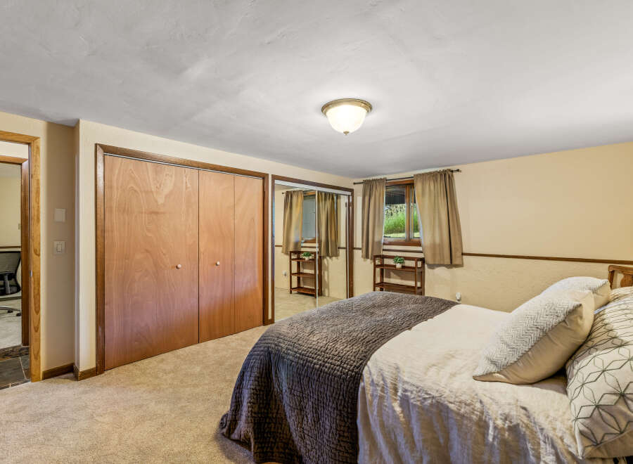 Discover comfort and style in this inviting bedroom, featuring a spacious closet with elegant wood doors and mirrored panels for an enhanced sense of space.