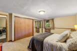 Discover comfort and style in this inviting bedroom, featuring a spacious closet with elegant wood doors and mirrored panels for an enhanced sense of space.