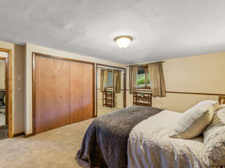 Discover comfort and style in this inviting bedroom, featuring a spacious closet with elegant wood doors and mirrored panels for an enhanced sense of space.