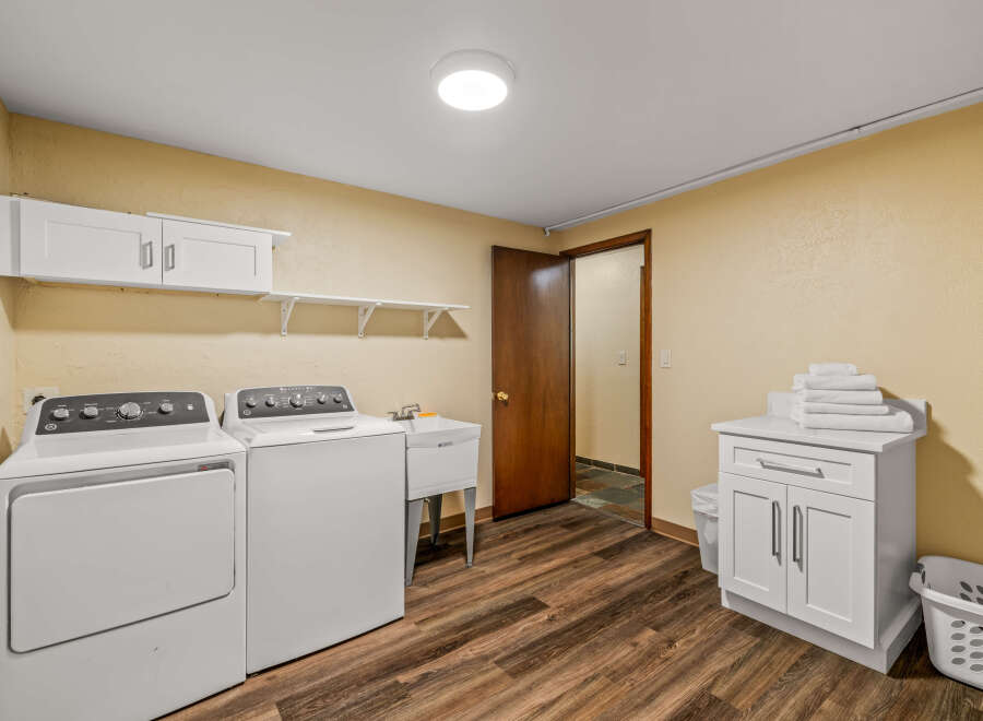 This spacious laundry room features a washer, dryer, and utility sink for all your cleaning needs.