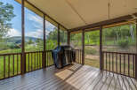 Enjoy the stunning mountain views from this screened-in porch, perfect for outdoor dining and relaxation.