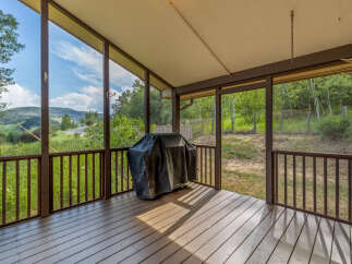 Enjoy the stunning mountain views from this screened-in porch, perfect for outdoor dining and relaxation.
