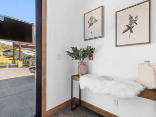 Step into this inviting entryway, featuring a stylish console table adorned with a fluffy white rug and decorative vases.