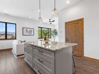 Experience modern living in this stunning open-concept space, featuring a sleek kitchen island with granite countertops and ample storage.