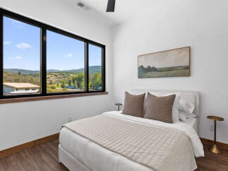 Experience breathtaking mountain views from this serene bedroom, featuring a large picture window that floods the space with natural light.