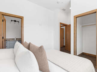 Experience comfort and convenience in this inviting bedroom, featuring a plush bed adorned with decorative pillows.