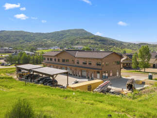 Discover this modern commercial building nestled against a backdrop of lush green mountains.