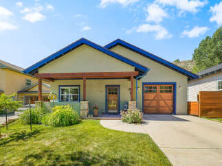 Charming single-family home featuring a welcoming covered porch with wooden beams and stone accents.