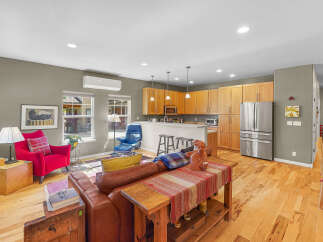 Experience comfortable living in this open-concept home featuring a spacious living area seamlessly connected to a modern kitchen.