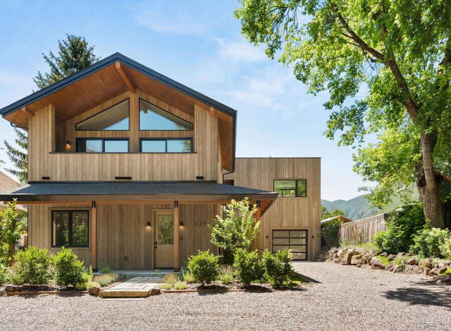 Experience modern mountain living in this stunning wood-clad home, featuring a striking A-frame roof and expansive triangular windows that capture breathtaking views.