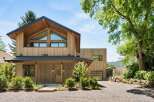 Experience modern mountain living in this stunning wood-clad home, featuring a striking A-frame roof and expansive triangular windows that capture breathtaking views.