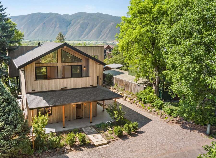 Experience modern mountain living in this stunning architectural home, featuring a striking wood-clad exterior and expansive triangular windows that capture breathtaking views.