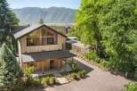 Experience modern mountain living in this stunning architectural home, featuring a striking wood-clad exterior and expansive triangular windows that capture breathtaking views.