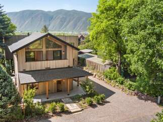 Experience modern mountain living in this stunning architectural home, featuring a striking wood-clad exterior and expansive triangular windows that capture breathtaking views.