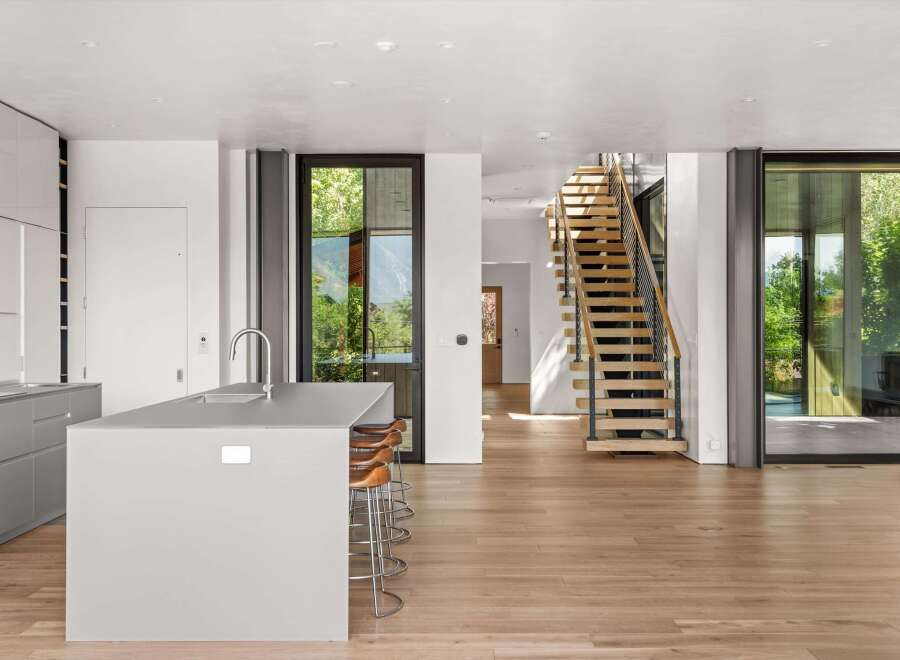 Experience modern living in this open-concept space featuring a sleek grey kitchen island with bar seating, perfect for entertaining.