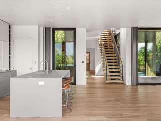 Experience modern living in this open-concept space featuring a sleek grey kitchen island with bar seating, perfect for entertaining.