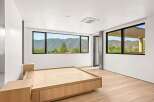 Experience breathtaking mountain views from this modern bedroom, featuring expansive windows that frame the stunning landscape.