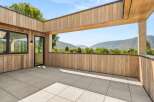 Experience breathtaking mountain views from this expansive modern balcony, perfect for outdoor living and entertaining.
