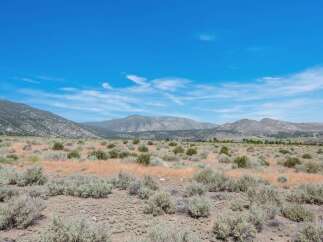 Discover this expansive, undeveloped parcel offering breathtaking panoramic views of the surrounding mountains and vast open skies.