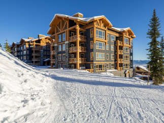 Experience luxury mountain living in this stunning ski-in/ski-out condominium complex, perfectly situated on a pristine snowy slope.
